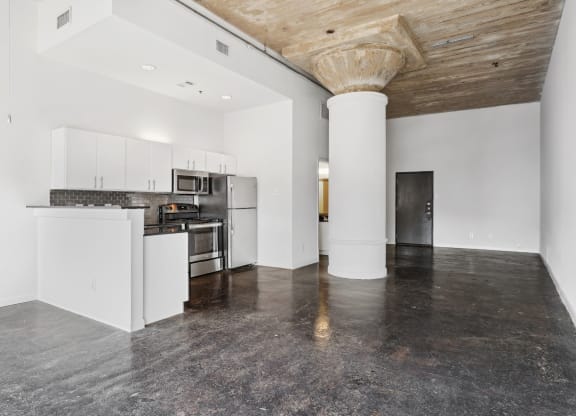 Loft kitchen and living area with polished concrete floors | Adam Hats Lofts from Deep Ellum Lofts in Dallas, TX