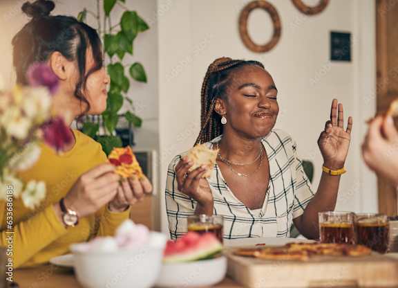 Two women are eating pizza and drinking soda at a table.