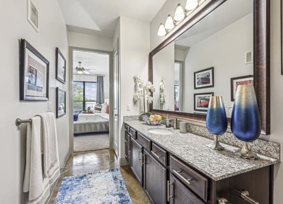 Elegant bathroom with granite countertops and modern fixtures at Allusion at West University apartments in Houston, TX