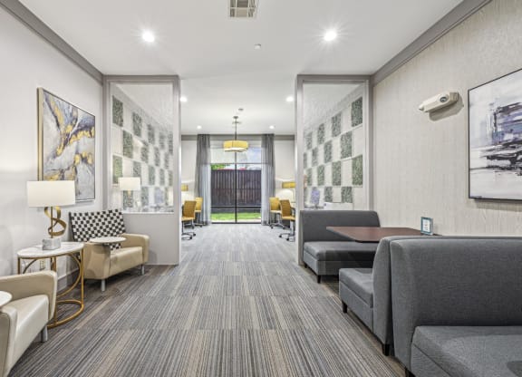 Business center with seating areas and workstations at Allusion at West University apartments in Houston, TX.