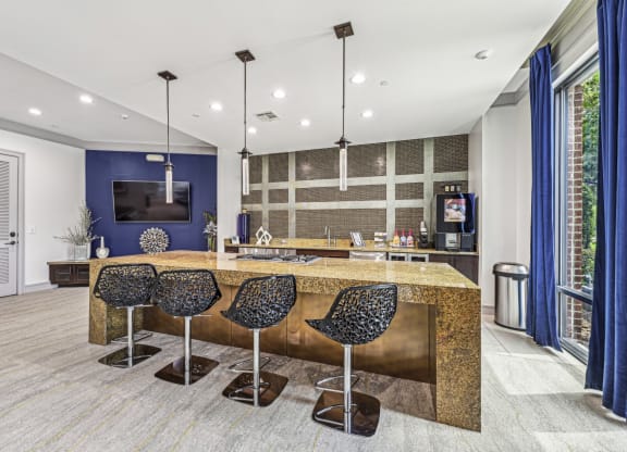 Sleek catering kitchen with a large island and bar seating at Allusion at West University apartments in Houston, TX.