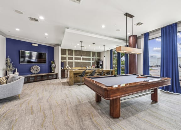 Stylish clubroom with a pool table and seating areas at Allusion at West University apartments in Houston, TX