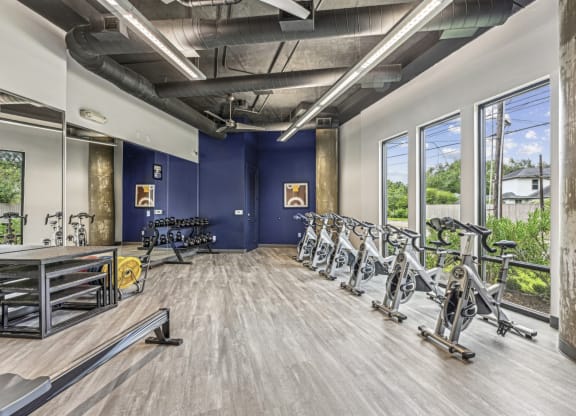 Fitness room featuring spin bikes and a variety of free weights at Allusion at West University apartments in Houston, TX