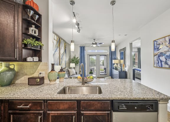 Open-concept kitchen and living area with a breakfast bar and stylish decor at Allusion at West University apartments in Houston, TX