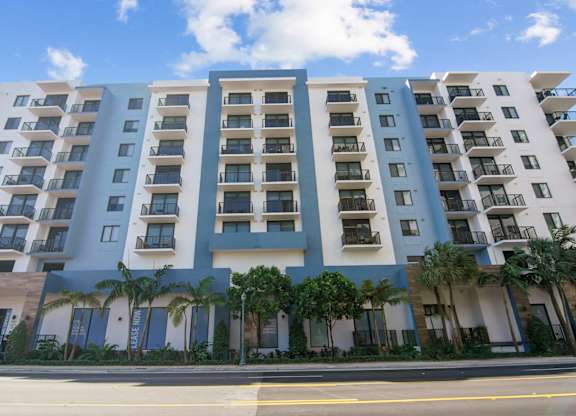 A large apartment building with balconies and doors.