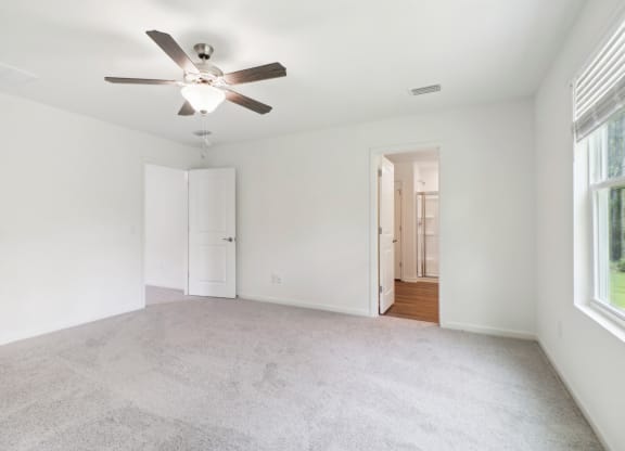 Master bedroom with ceiling fan and carpeted flooring at Beacon at Ashley River Landing in Summerville, SC