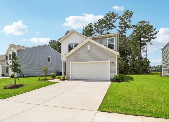 Side view of a two-story house with a white and gray exterior at Beacon at Ashley River Landing in Summerville, SC
