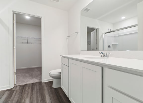 Maple bathroom with white cabinetry and a large mirror at Beacon at Ashley River Landing in Summerville, SC