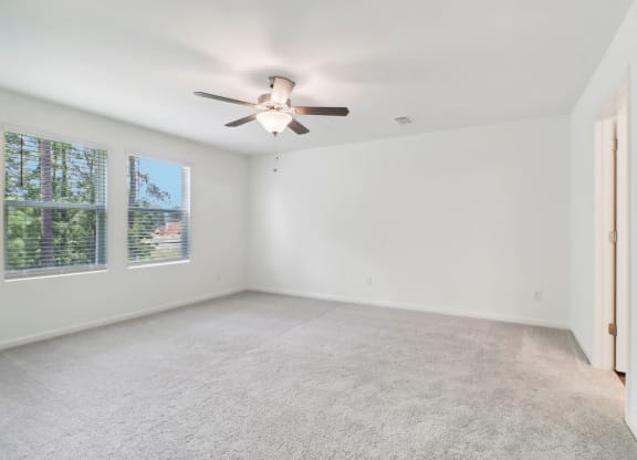 Spacious master bedroom with carpet floor and ceiling fan at Beacon at Ashley River Landing in Summerville, SC