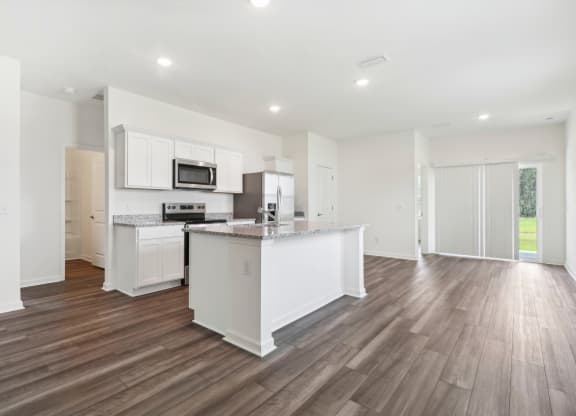Oak open kitchen and living room with white cabinets and a counter top at Beacon at Ashley River Landing in Summerville, SC