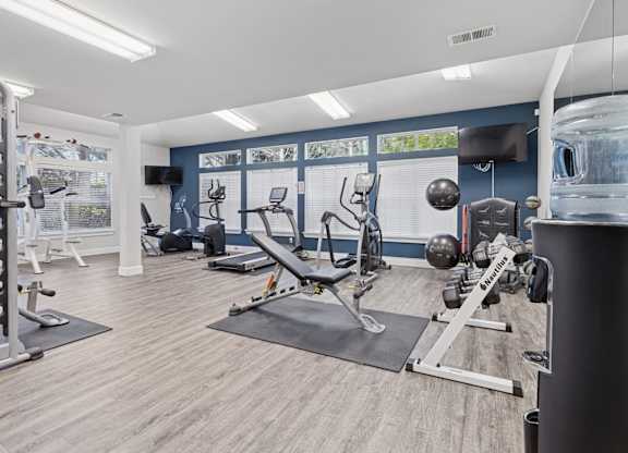 A gym with a variety of equipment including weights, treadmills, yoga equipment, and ellipticals at Abbey Rowe Apartments in Olympia, WA