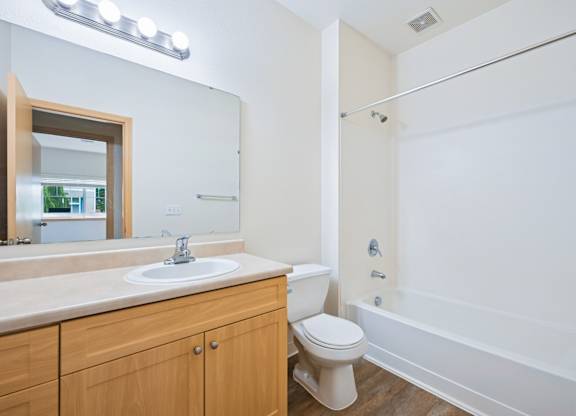 Soho bathroom with a vanity sink, toilet, and bathtub at Abbey Rowe Apartments in Olympia, WA