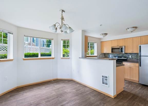 York dining room and kitchen with four windows and wood cabinets at Abbey Rowe Apartments in Olympia, WA