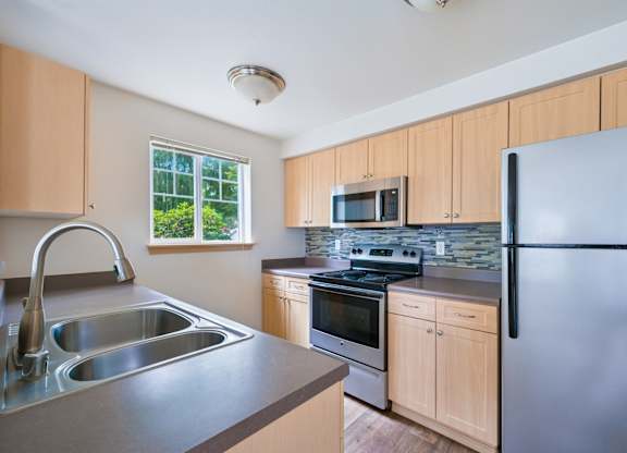 York kitchen with stainless steel appliances and a window at Abbey Rowe Apartments in Olympia, WA