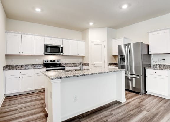 a kitchen with an island and stainless steel appliances