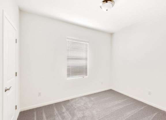 a bedroom with white walls and carpet