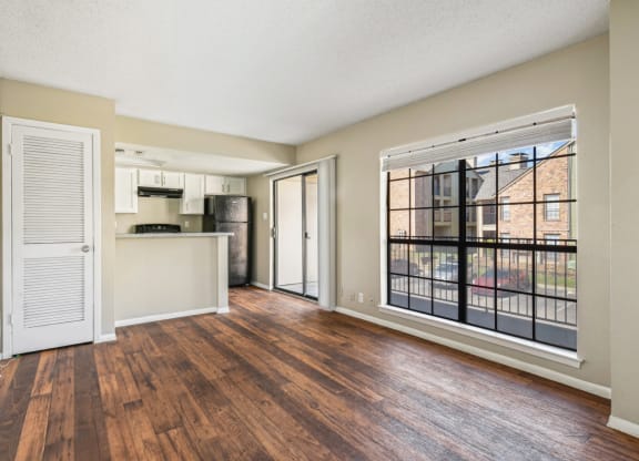 Spacious living room with large windows at Bandera Crossing apartments in San Antonio, TX