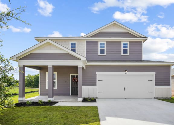 a house with gray siding and a gray garage door at Beacon at Bunton Creek, Kyle