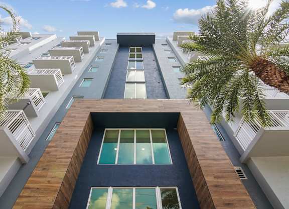 A tall apartment building with a modern entrance at Blue Lagoon 7 Apartments in Miami, FL