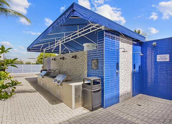 Grilling station with bbq grills and a showerhead at Blue Lagoon 7 apartments in Miami FL