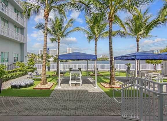 A sundeck with shaded seating and the lagoon in the background at Blue Lagoon 7 Apartments in Miami, FL
