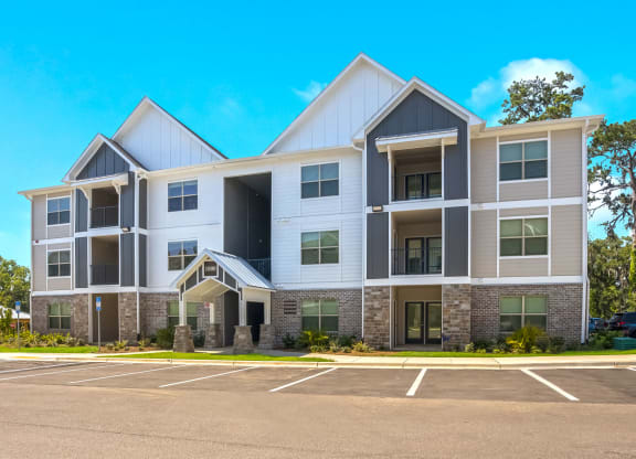 a large apartment building with a parking lot in front of it