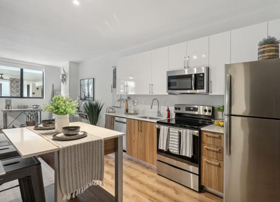 A kitchen with stainless steel appliances and a dining table at Bay Village 1 Apartment in Palmetto Bay, FL
