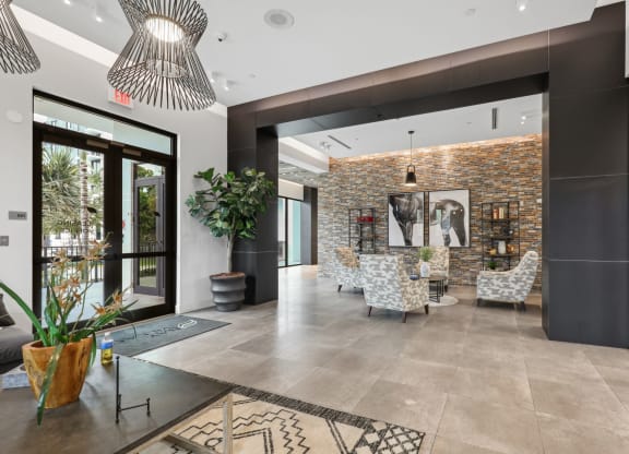 a lobby with chairs and a table and a glass door