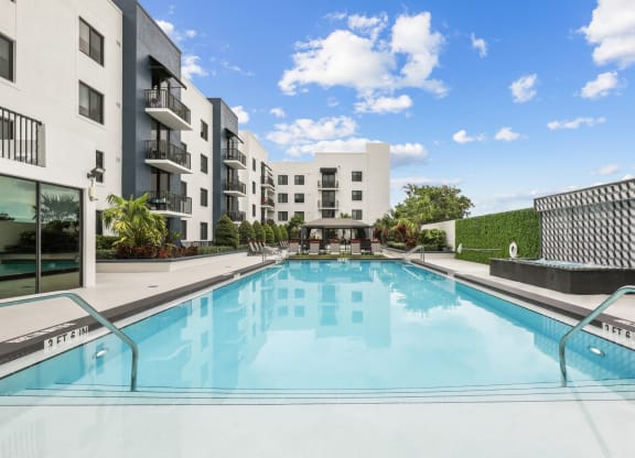 a swimming pool with an apartment building in the background