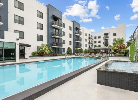a swimming pool with an apartment building in the background