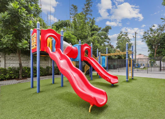 Red playground with slides at Bay Village 1 in Palmetto Bay, FL