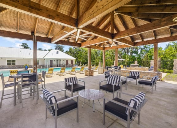Shaded outdoor seating by the pool at Capital Grand Apartments in Tallahassee, FL