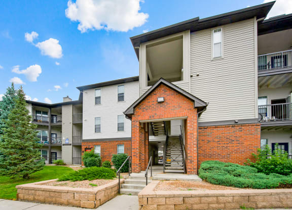View of the entryway of one of our apartment buildings with stairs and 3 floors at Greensview Apartments in Aurora, CO