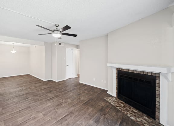 a living room with a fireplace and a ceiling fan