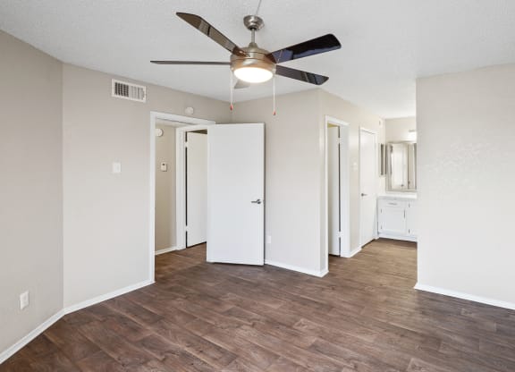 a bedroom with hardwood flooring and a ceiling fan