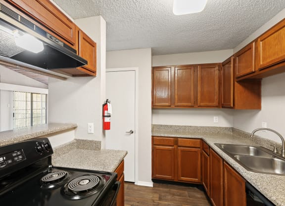a kitchen with wood cabinets and granite countertops