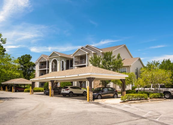 Covered parking spaces by the apartment buildings at Angel Landing Apartment Homes in Pensacola, FL