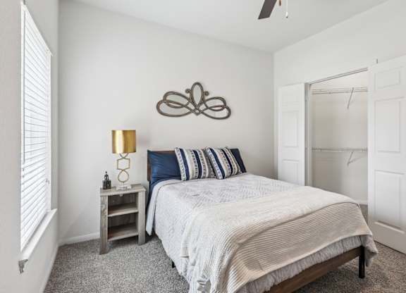 B3 bedroom with a bed, nightstand, and a ceiling fan at Creekside on Parmer Lane Apartments in Austin, TX