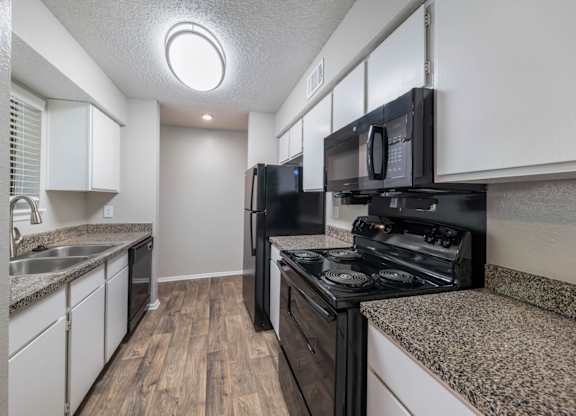 Crooked Stick kitchen with black appliances and white cabinets at Westdale Hills apartments
