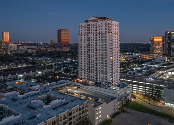 an aerial view of apartment building in the middle of a city at night at Dominion Post Oak in Houston, TX