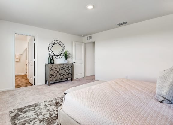 master bedroom with carpet floor, a mirror and a dresser
