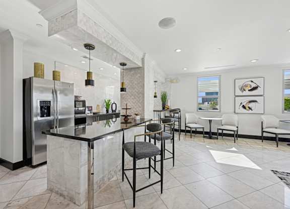 Modern community kitchen with an island and stainless steel appliances for all residents to enjoy at Dominion Post Oak apartments in Houston, TX
