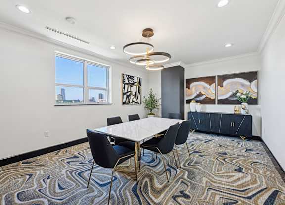 Conference room with long table and seats and window looking out to city at Dominion Post Oak apartments in Houston, TX