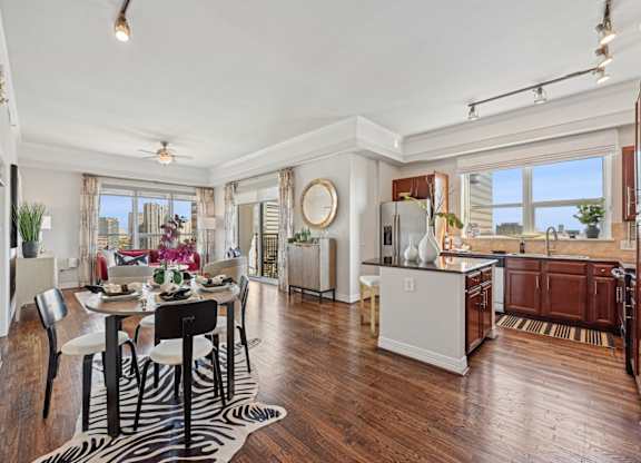 Model kitchen and dining room with a zebra print rug and under the dining table at Dominion Post Oak apartments in Houston, TX