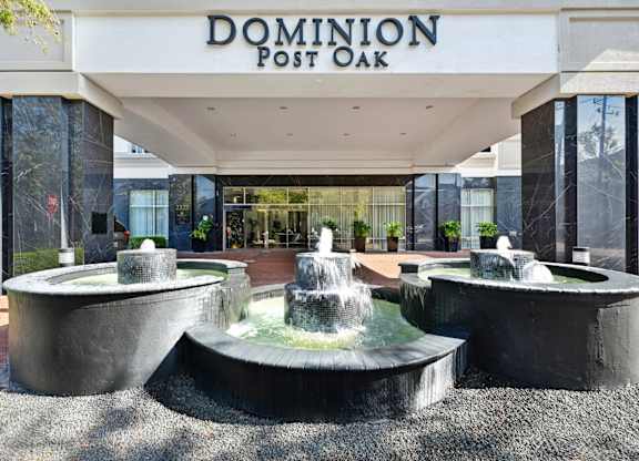 Main entrance to lobby with a fountain feature at Dominion Post Oak apartments in Houston, TX.
