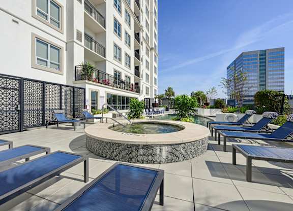 Rooftop pool and hot tub with lounge chairs at Dominion Post Oak apartments in Houston, TX