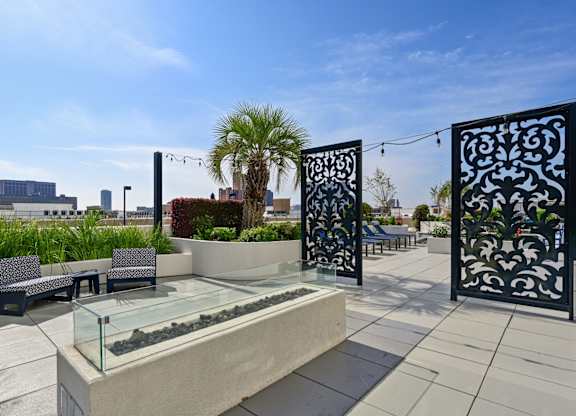 Rooftop patio with palm trees and a firepit at Dominion Post Oak apartments in Houston, TX