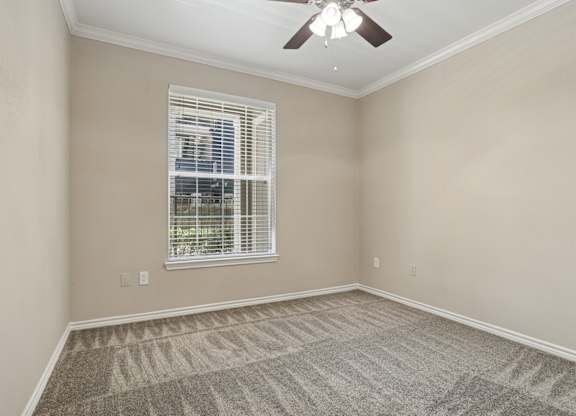 Edinburgh bedroom with a ceiling fan and a window at Encore at Buckingham Apartments in Richardson, TX