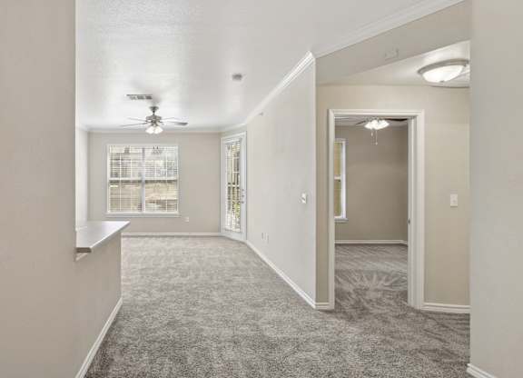Edinburgh living room  with a carpeted floor and a ceiling fan at Encore at Buckingham Apartments in Richardson, TX