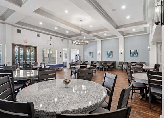 A large event room with round tables and chairs at Encore at Buckingham Apartments in Richardson, TX